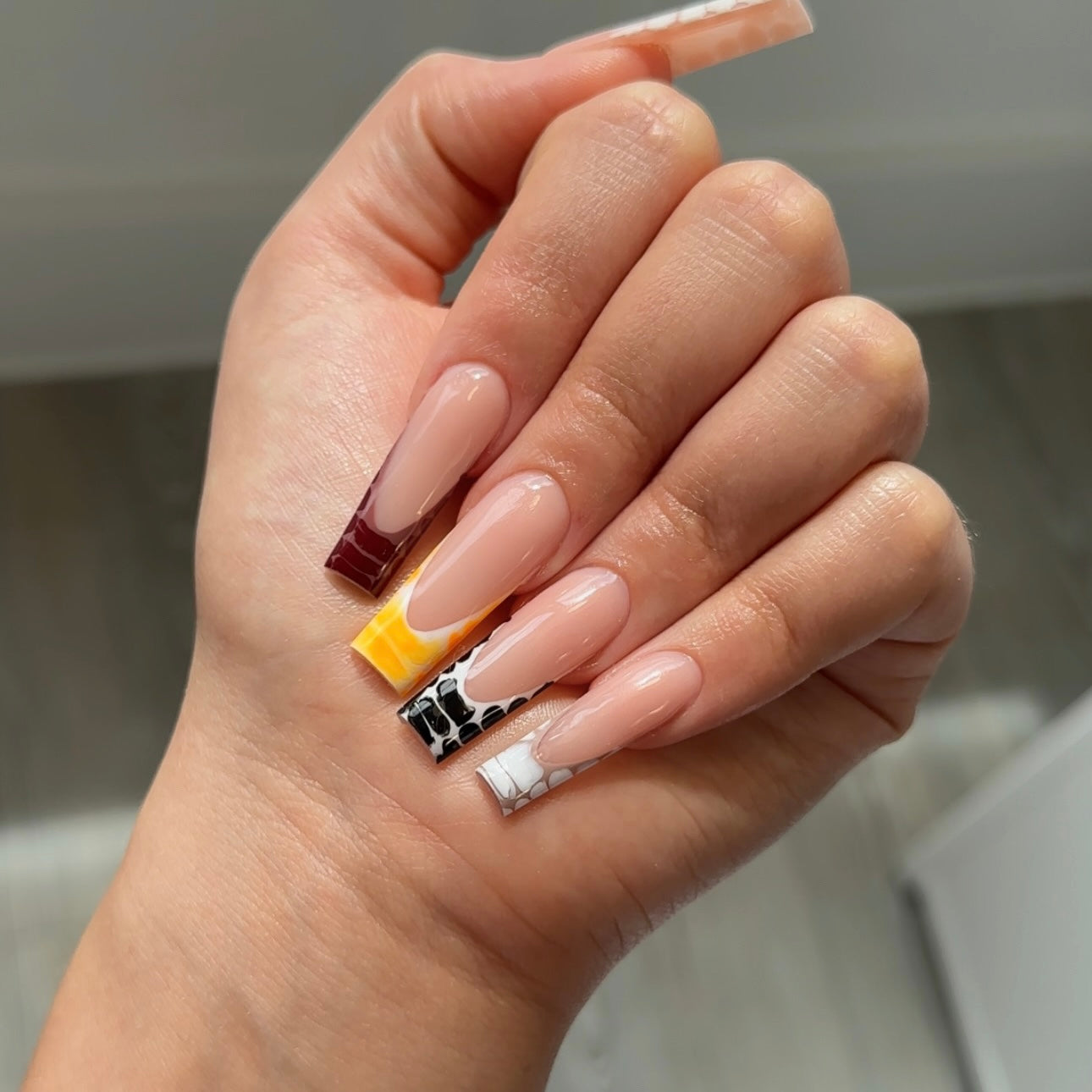 Creative acrylic nail art with nude base by aleyahnailedit London.